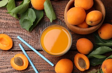 Apricot juice in glass, fresh fruits and drinking straws on wooden table, flat lay © New Africa