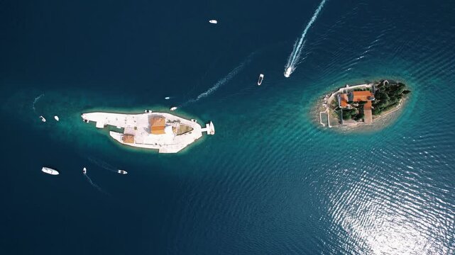 Scenic coastal scene. Aerial perspective of pier and island. Beautiful turquoise sea with boat wakes near Perast