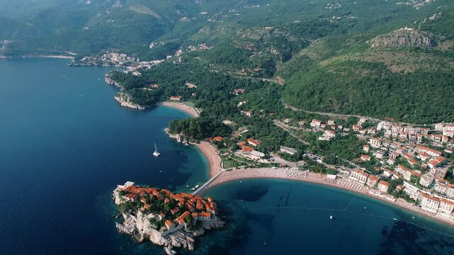 Sunny coastal area with colorful roofs. Scenic aerial perspective of lively beach town surrounded by lush islands