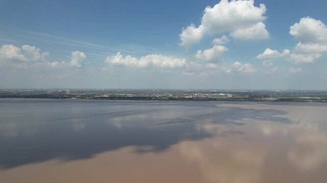 Cloud reflections across the broad Qiantang River in China