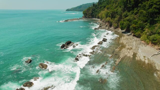 Aerial view of Pacific Ocean waves hitting rocky Costa Rica cliffs at Playa Caballeros