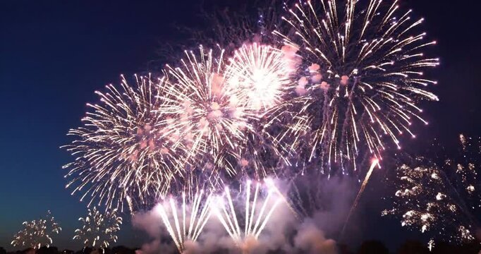  Fireworks - patriotic fourth of july firecracker display exploding in the night sky with red, white, and blue sparkles. isolated blue background. 4K Video 60 fps