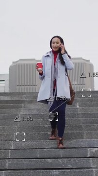 Animation of financial data processing over woman using smartphone in city