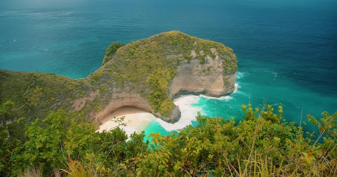 Turquoise ocean water hits the white sand of Kelingking Beach Nusa Penida Bali
