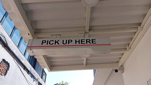 Illuminated Pick Up Here Sign Under Drive-Thru Awning with CCTV Camera