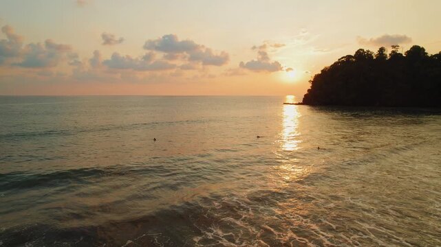 Surfers waiting for waves during golden hour at Playa Hermosa beach in Costa Rica