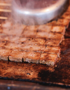 Wagyu beef skewers grilling on hot teppanyaki teppan iron plate, premium Japanese marbled meat on wooden sticks, traditional street food festival, Tokyo, Japan, market with local vendor stalls cooking