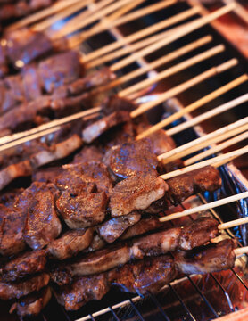 Wagyu beef skewers grilling on hot teppanyaki teppan iron plate, premium Japanese marbled meat on wooden sticks, traditional street food festival, Tokyo, Japan, market with local vendor stalls cooking