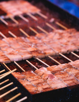 Wagyu beef skewers grilling on hot teppanyaki teppan iron plate, premium Japanese marbled meat on wooden sticks, traditional street food festival, Tokyo, Japan, market with local vendor stalls cooking