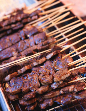 Wagyu beef skewers grilling on hot teppanyaki teppan iron plate, premium Japanese marbled meat on wooden sticks, traditional street food festival, Tokyo, Japan, market with local vendor stalls cooking