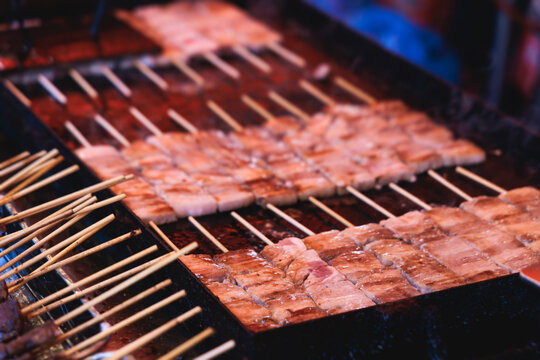 Wagyu beef skewers grilling on hot teppanyaki teppan iron plate, premium Japanese marbled meat on wooden sticks, traditional street food festival, Tokyo, Japan, market with local vendor stalls cooking