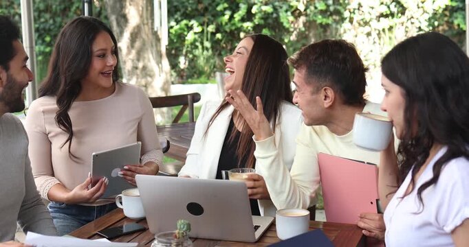 Latin business teamwork of friends using laptop in a coffeeshop terrace in Mexico Latin America. Portrait of hispanic people employees working outdoors
