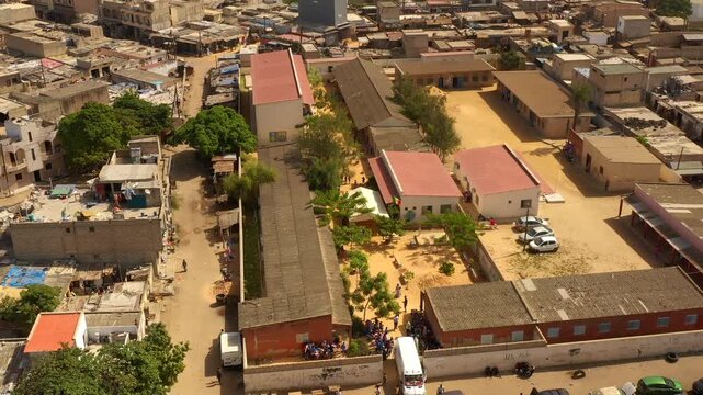 Drone shot school buildings and house rooftops in rural Senegal community outside Dakar