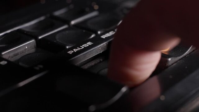 Finger presses control button down to pause buttons on vintage analog audio equipment, raise to release