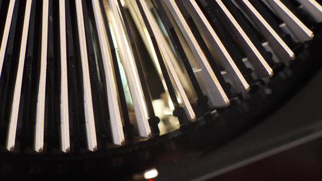 Close detail of circular slide projector carousel filled with mounted photographic slides spinning and dropping into mount viewer