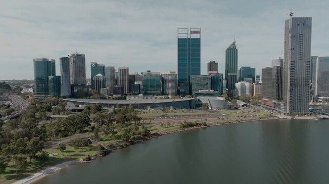 mooth aerial drone shot overlooking Perth CBD and the Swan River, highlighting the city&rsquo;s skyline, waterfront, surrounding roads, and distinctive Western Australian urban landscape.