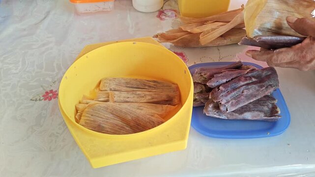 Hand Unwrapping Corn Husk Tamale and Serving It on a Plate