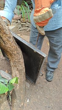 Detaching Metal Sheet from Base Using Screwdriver and Wooden Mallet Hits