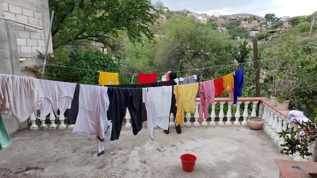 Drone Aerial View of Person Hanging Laundry on Rooftop Clothesline