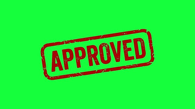 Close-up of a red 'Approved' rubber stamp on green background