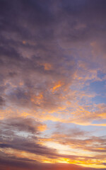 Fototapeta premium Vibrant Sunset Sky with Fiery Orange and Purple Clouds,A dramatic and colorful sunset sky filled with textured clouds. The setting sun casts intense golden-orange and warm yellow light from.