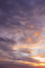 Fototapeta premium Vibrant Sunset Sky with Fiery Orange and Purple Clouds,A dramatic and colorful sunset sky filled with textured clouds. The setting sun casts intense golden-orange and warm yellow light from.