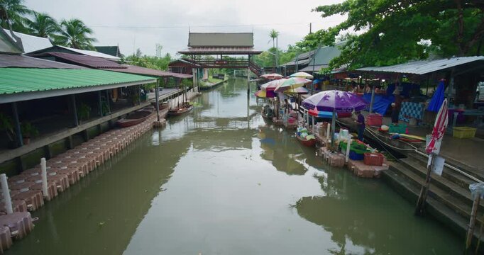Crowded wooden boats in canal with fruits, vegetables, foods and grocery products for sell and trade by villagers at Tha Kha traditional floating market Samut Sogkhram, Thailand