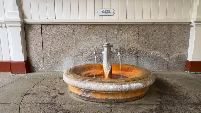 A fountain in Karlovy Vary offers mineral water. The spot shows the various textures and colors of the fountain's surface. Spring 2, Charles IV Spring, Pramen Karla IV in Market Colonnade