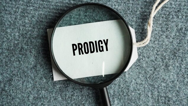 Magnifying glass and paper tag with the words Prodigy: A young person with exceptional qualities or abilities.