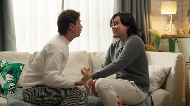 couple having intense heated argument on living room sofa, tense body language and raised voices, relationship conflict and emotional distress concept, dramatic indoor lighting.