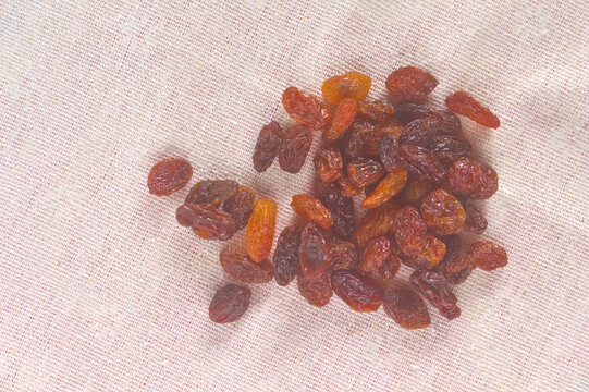 Pile of raisins on a woven cotton cloth with copy space