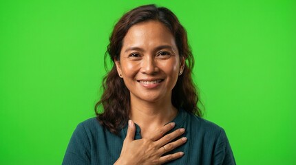 Fototapeta premium Smiling Mature Asian Woman Gesturing Gratitude with Hand on Chest over Green Screen Background