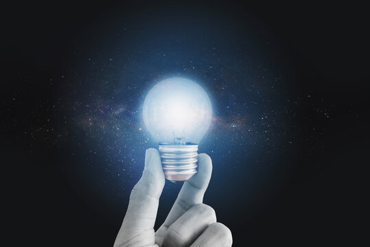 Hand holding bright light bulb, with stars. Imagination, innovative, ideas, and technology concept 