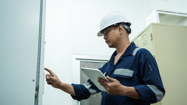 Environment Engineers checking data electrical control panels, air pollution reduction on digital displays.Technician management continuous emission monitoring system in factory and industry. ESG. ECO