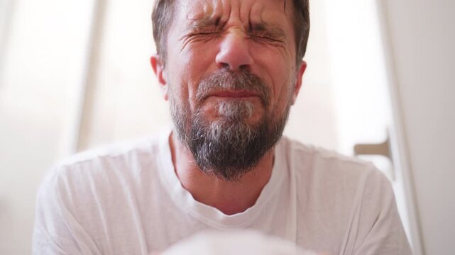 Close-up of man straining while sitting on toilet, showing facial discomfort and frustration during difficult bowel movement, representing constipation, digestive problems and gut health.