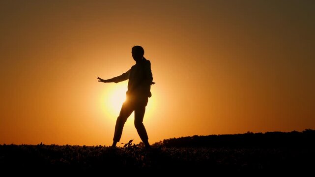 Farmer Dancing in Full Silhouette Against Setting Sun