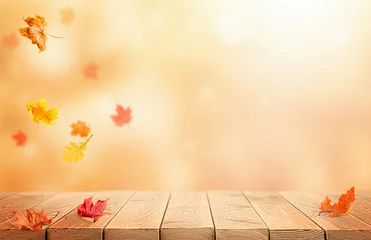 Autumn nature background with falling leaves and a wooden table. Background for educational, Thanksgiving, or Harvest Day themes. © Ирина Гутыряк