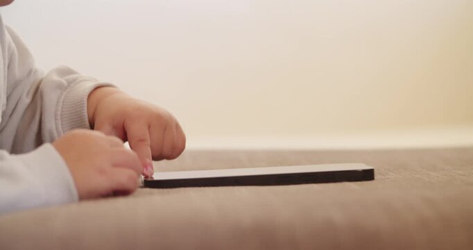 Child's finger pressing, scrolling, tapping on  mobile phone screen. Little child learns to use new technologies.  Baby pressing with finger on phone touch screen, close-up and soft focus.