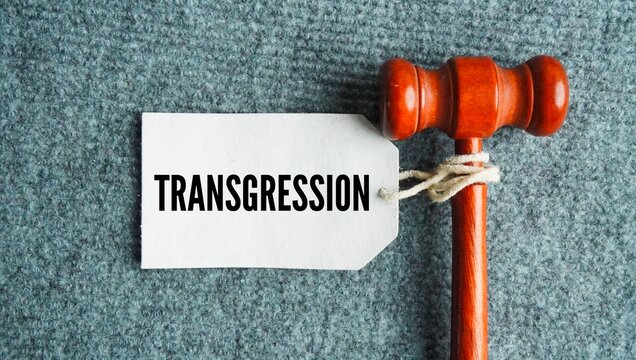 Judge's gavel and paper tag with the words transgression is an act that breaks a law, moral rule, or official code of conduct