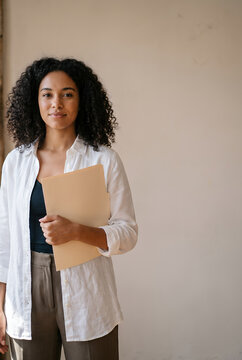 Young African American woman holding folder looking at camera