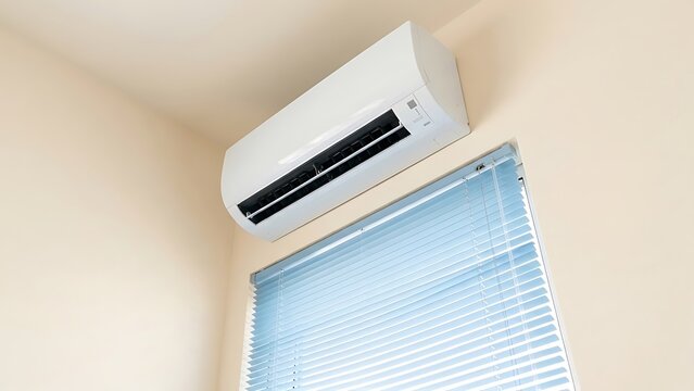 Energy-efficient air conditioner unit mounted on wall above window blinds, providing indoor climate control and comfort in modern room