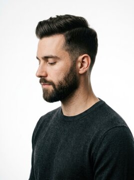 Thoughtful Man with Beard and Stylish Haircut Looking Down.