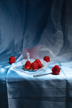 Elegant strawberry still life on blue satin with pearls