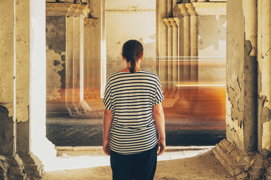 Woman standing still under classic columns watching blurred vehicle traffic pass by. Concept of time passing, stillness in motion, urban life, and speed contrast.