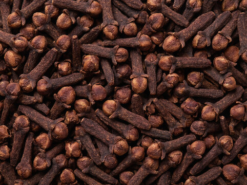 Macro close-up texture of dried cloves filling the frame, top view of organic aromatic spice background