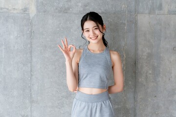 Fototapeta premium 笑顔でOKサインする日本人女性ヘルシーなフィットネス姿