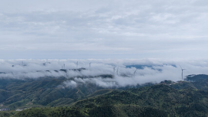 Wind Turbines Above Misty Mountain Landscape © LuuDieuThanh