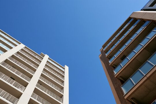 高層マンション群の間に広がる青空見上げる都会の風景