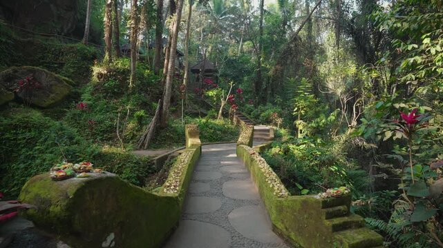 Lush tropical garden pathways and ancient stone steps leading through the historic Goa Gajah Temple archaeological complex in Ubud, Bali, Indonesia