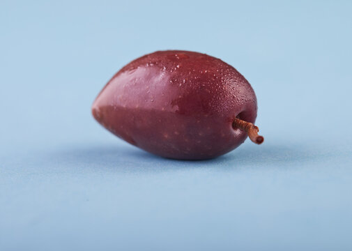 Colorful olive on a blue background, side view.